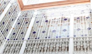 okno z białym i niebieskim witrażem w obiekcie Amazing Sevilla Apartamento w Sewilli