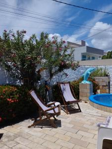 two lawn chairs sitting next to a swimming pool at Pousada Harmonia in Tamandaré
