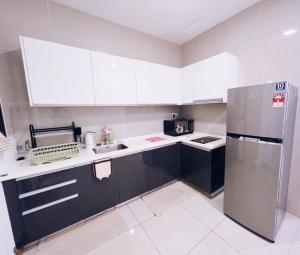 a kitchen with white cabinets and a stainless steel refrigerator at [PROMO]Connected train 2 Bedroom ABOVE MALL (22) in Kuala Lumpur