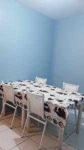 een eettafel met stoelen en een tafelkleed bij Residencial dos Moleques in Capão da Canoa