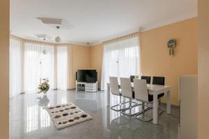 a living room with a table and chairs and a television at Private House in Hannover