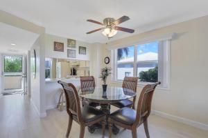 a dining room with a table and chairs and a ceiling fan at Bright condo in community with pool/steps to beach in Marco Island