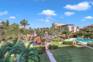 a resort with a pool and palm trees at Bright condo in community with pool/steps to beach in Marco Island