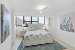 a white bedroom with a bed and a window at Beachfront condo with pool, tennis and fitness center in Marco Island +23 photos
