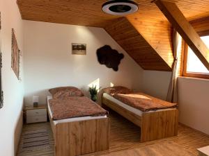 a bedroom with two beds and a wooden ceiling at Penzión Pegas in Bratislava