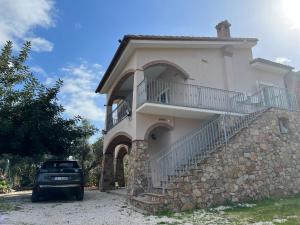 un coche aparcado frente a un edificio con balcón en Casa vacanze Sardegna B, en Tertenìa