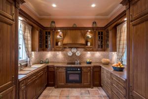 a kitchen with wooden cabinets and a stove top oven at Pantaleon House in Ano Syros