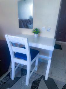 a white desk with a chair and a mirror at Ruaka studio Airbnb in Ruaka