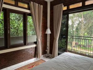 a bedroom with windows and a bed and a balcony at Arunni garden in Bogor