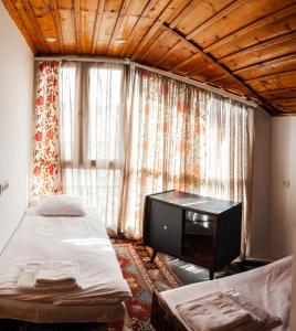 a bedroom with two beds and a television in front of a window at The Forgotten Kingdom in Lchashen