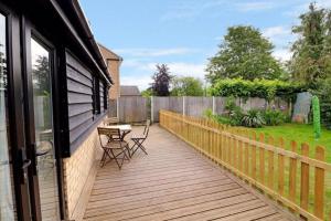 a wooden deck with a table and chairs on it at Stylish, Country, Self-Contained Annexe near Cambridge in Colne