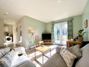 a living room with a couch and a table at Stylish, Country, Self-Contained Annexe near Cambridge in Colne