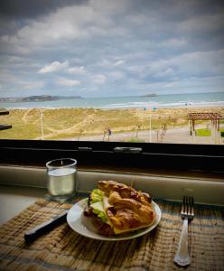 a plate of food on a table with a view of the beach at Vistas al Mar in Somo