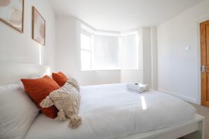 Hampton House - Sleeps 7 - Free Parking and WiFi في بريستول: سرير ابيض عليه حشره محشوه