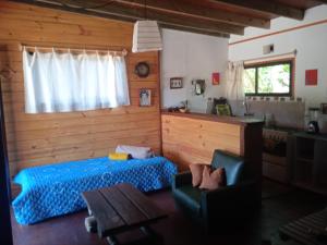 1 dormitorio con cama, mesa y ventana en Cabaña La Federica, en La Paloma