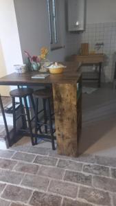 einen Holztisch in einer Küche mit einer Theke in der Unterkunft CASA DEL MAESTRO in Castel di Lama
