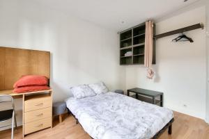 Habitación pequeña con cama y escritorio. en Studio équipé à ivry sur seine en Ivry-sur-Seine