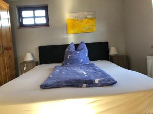 a blue blanket sitting on top of a bed at Café Landart im Thüringer Finistère in Plaue