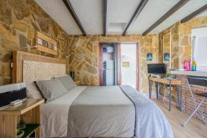 a bedroom with a bed and a stone wall at Sunny Studio Nerja in Nerja
