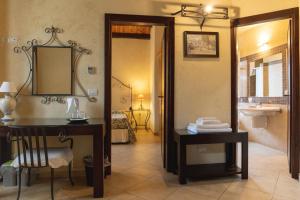 baño con lavabo, escritorio y espejo en Agriturismo Villa Cefalà, en Santa Flavia