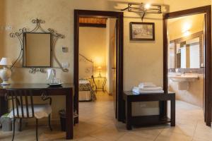 a bathroom with a sink and a desk and a mirror at Agriturismo Villa Cefalà in Santa Flavia