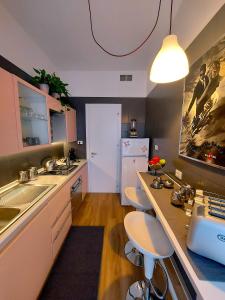 uma cozinha com um lavatório e um balcão com bancos em Gebel Grin em Palermo