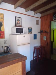 cocina con nevera blanca y microondas en Cabaña La Federica, en La Paloma