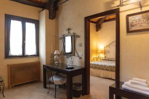 サンタ・フラーヴィアにあるアグリツーリズモ ヴィラ チェファラの鏡、デスク、ベッド1台が備わるベッドルーム1室が備わります。