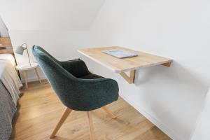 einem grünen Stuhl neben einem Holztisch in der Unterkunft Casa Verde: Küche, TV, Nespresso, im Grünen in Starnberg