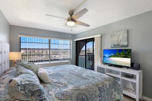 een slaapkamer met een bed en een flatscreen-tv bij Anglers Cove M-502 in Marco Island