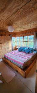 a bed in a room with a wooden ceiling at Casa del río in Cochrane