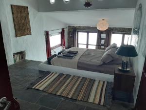 um quarto com uma cama, um candeeiro e um tapete em Casas Letizia e Sebastião em Monsaraz
