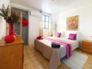 um quarto com uma cama grande e almofadas roxas em Grande villa climatisée,jardin, ideale famille, groupe amis, proche port de peche,littoral em Le Diamant