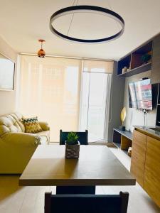 a living room with a table and a yellow couch at Departamentos Concepcion Centro in Concepción