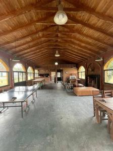 Habitación grande con mesas y sillas en un edificio en Casa de campo con laguna y piscina en Luján