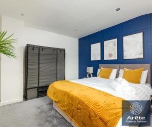 a bedroom with a large bed with a blue wall at Arete Serviced Accommodation - 3 Bedrooms, 4 Beds, with Parking in Merstham