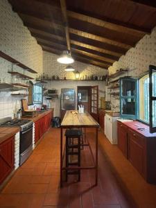 una gran cocina con una mesa de madera. en Casa de campo con laguna y piscina en Luján