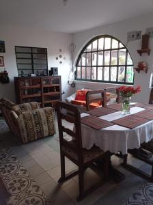 ein Esszimmer mit einem Tisch und einer Blumenvase darauf in der Unterkunft Habitación Privada en Mongui in Monguí