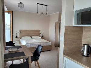 a bedroom with a bed and a table and a dining room at Apartamenty ELIASZ in Ustronie Morskie