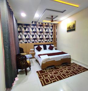 um quarto com uma cama e uma cadeira num quarto em Hotel Amigo em Ratlām