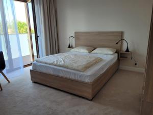 a bedroom with a large bed with a wooden headboard at Apartamenty ELIASZ in Ustronie Morskie