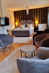 a living room with a bed and a couch and chairs at Hotell Monica in Hagfors