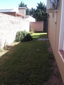 a yard next to a building with a wall at Ayres Pampeanos in Santa Rosa