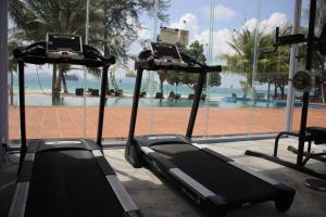 瓜隆島的住宿－SCARLET SAILS BUNGALOW，健身房在游泳池前设有两台跑步机