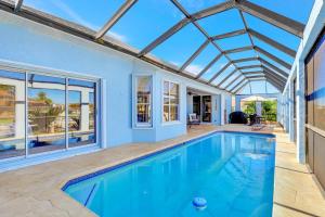マルコ・アイランドにあるLovely Pet-friendly waterfront home with pool and dockのガラス天井の家のスイミングプール