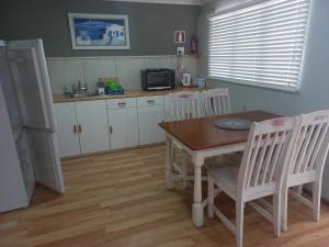 a kitchen with a table and chairs and a refrigerator at I Could Live Here - guest house in Sedgefield