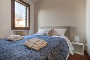 a bedroom with a bed with a blue blanket on it at enJoy Home - Bilocale sulle Riviere nel cuore di Padova in Padova