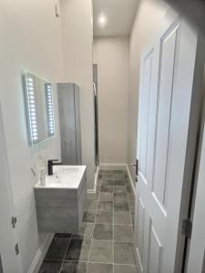 a white bathroom with a sink and a mirror at The Garden Room YORK in York