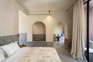 1 dormitorio con 1 cama grande y chimenea en Maison Brummell Majorelle, en Marrakech