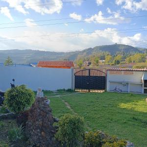 un patio con una pared blanca y una puerta en Cabaña Villa Graciela, en Paipa